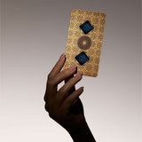 Hand holding Aires Tech Lifetune Zone Max EMF protection device against a neutral background