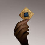 Hand holding Lifetune Zone EMF protection device, featuring intricate design and resonator pattern against a soft gradient background.