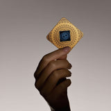 Hand holding Lifetune Zone EMF protection device, featuring intricate design and resonator pattern against a soft gradient background.