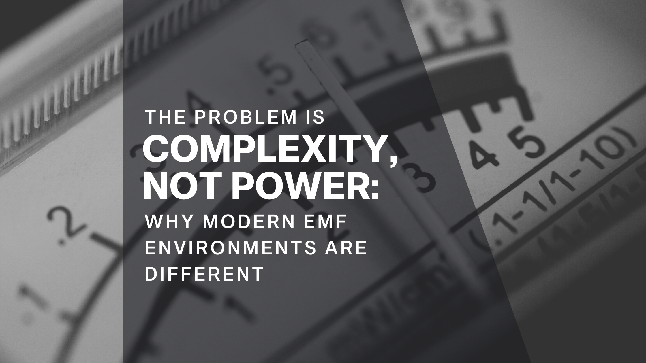Close-up of an EMF meter in a technology-filled room with the blog title “Complexity Not Power” displayed on screen, emphasizing that EMF environments are defined by signal interaction rather than strength alone.