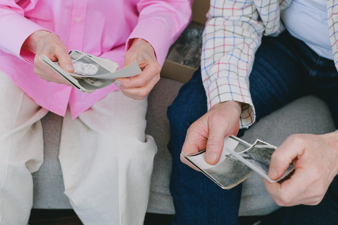 View of couple's hands holding photographs