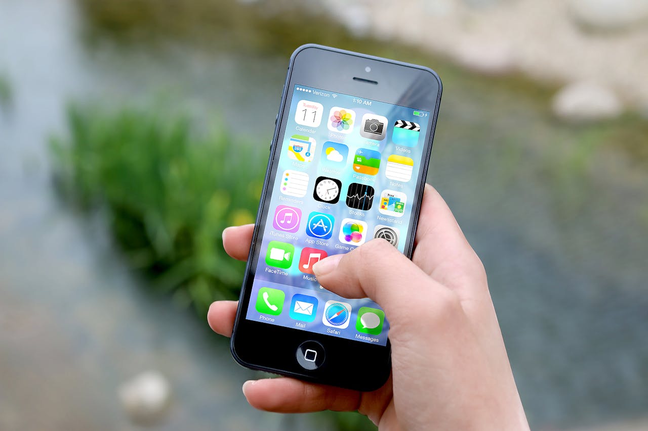 Hand holding an iPhone with the display on