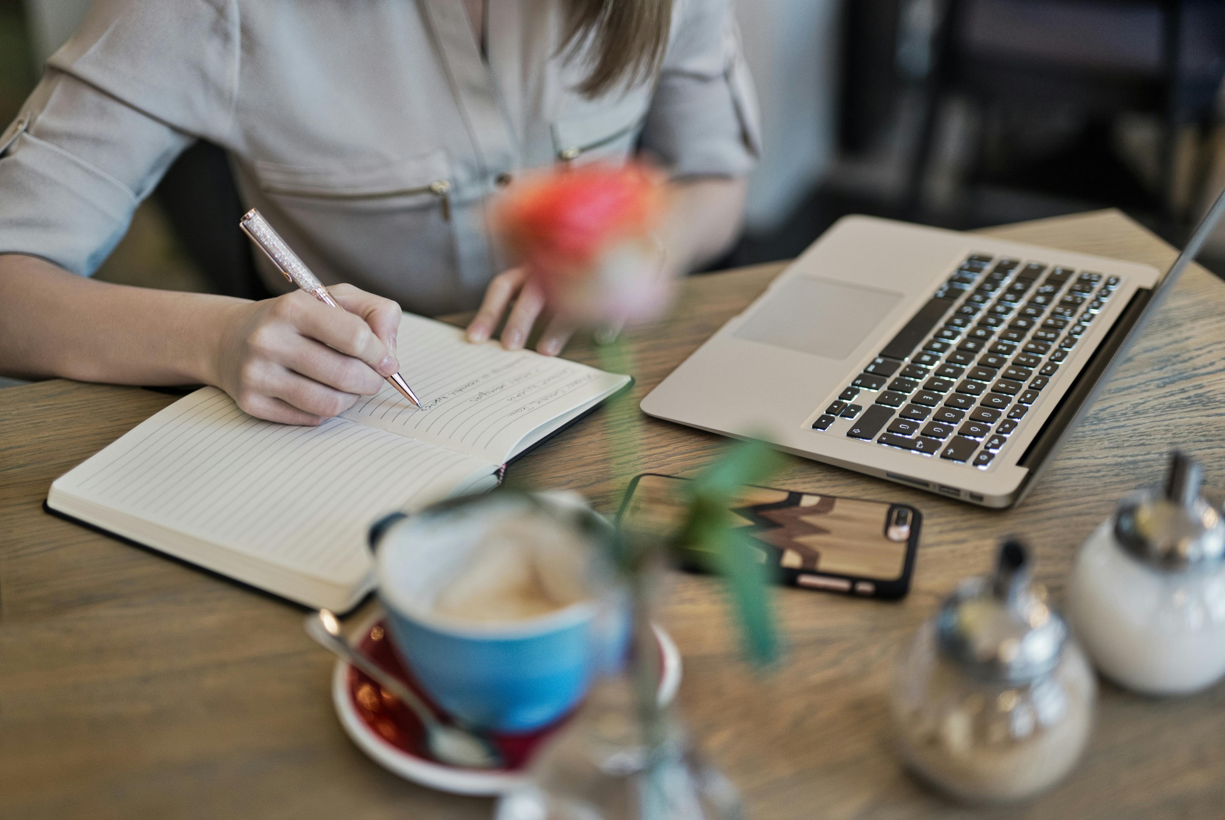 Tabletop with phone, laptop, and journal