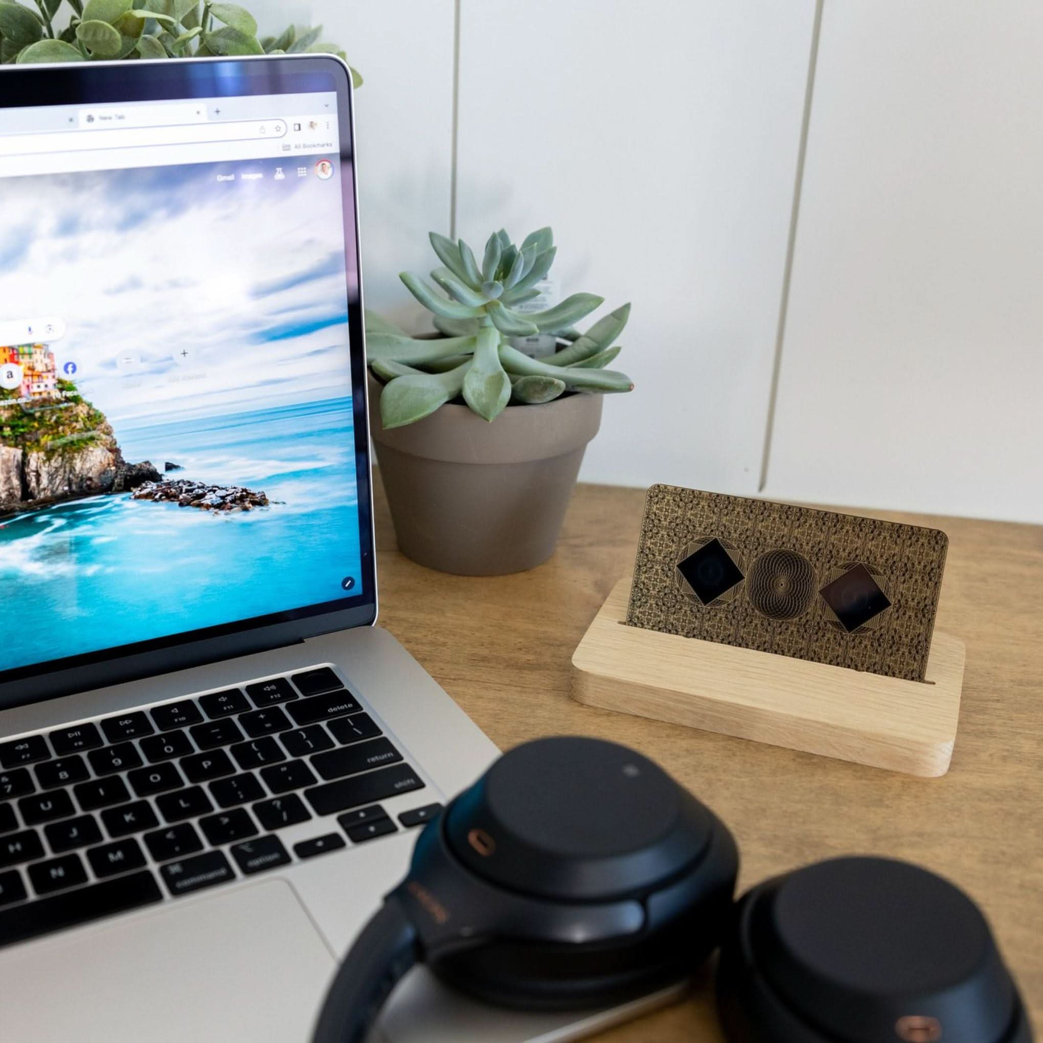 Aires Tech Lifetune Zone Max device placed on a wooden desk next to a laptop, headphones, and potted plant in a modern workspace